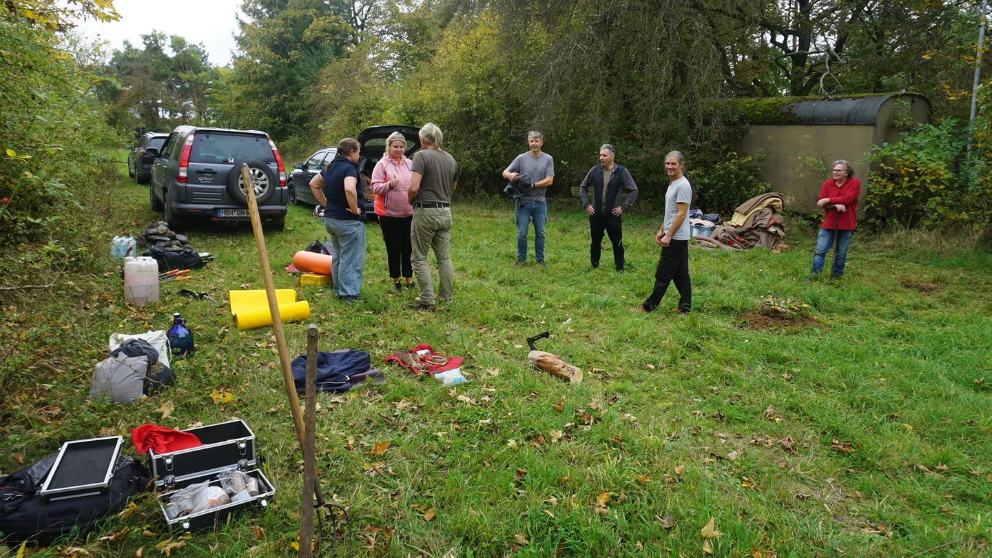 Teilnehmer einer früheren Schwitzhütte kommen auf einer Wiese zusammen.